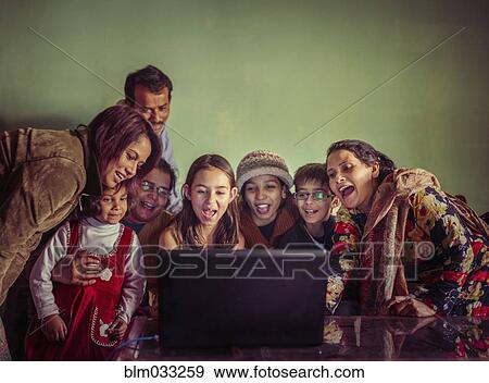Stock Photo - Multi-generation family videochatting on laptop. Fotosearch