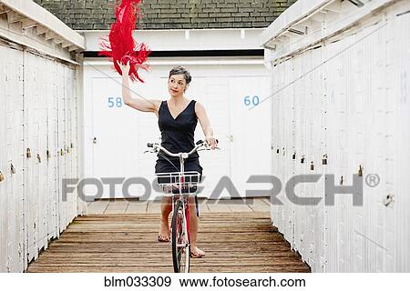 Older Caucasian woman riding bicycle on wooden dock View Large Photo Image Stock Photo - Older Caucasian woman riding bicycle on wooden dock. Fotosearch