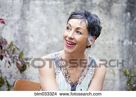 Picture - Older Caucasian woman sitting outdoors. Fotosearch