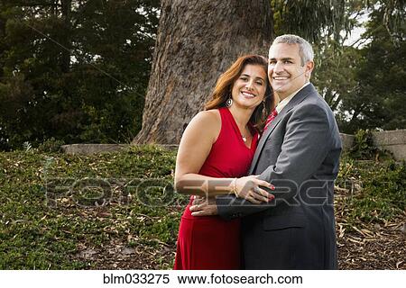 Stock Photography - Smiling couple hugging in formal wear. Fotosearch