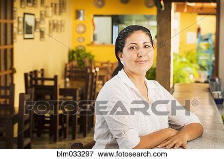Smiling woman at counter in restaurant View Large Photo Image Stock Photo - Smiling woman at counter in restaurant. Fotosearch