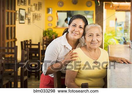 Smiling women at counter in restaurant View Large Photo Image Stock Photo - Smiling women at counter in restaurant. Fotosearch