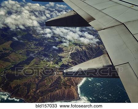 Aerial view of airplane wing flying over coastline View Large Photo Image Stock Image - Aerial view of airplane wing flying over coastline. Fotosearch