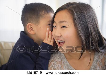 Asian boy whispering in ear of sister View Large Photo Image Stock Image - Asian boy whispering in ear of sister. Fotosearch