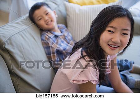 Asian brother and sister relaxing on sofa View Large Photo Image Stock Photography - Asian brother and sister relaxing on sofa. Fotosearch