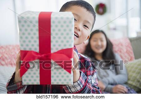 Stock Photograph - Asian brother with sister holding Christmas gift. Fotosearch