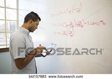 Stock Image - Asian businessman using digital tablet at whiteboard. Fotosearch