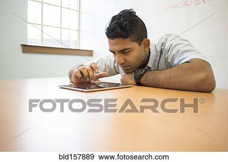 Asian businessman using digital tablet in office View Large Photo Image Stock Photo - Asian businessman using digital tablet in office. Fotosearch
