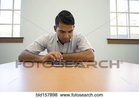 Stock Photo - Asian businessman using digital tablet in office. Fotosearch