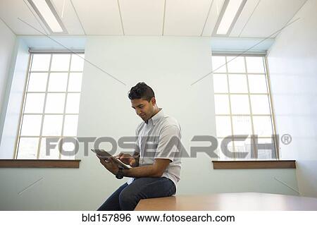 Stock Photograph - Asian businessman using digital tablet in office. Fotosearch