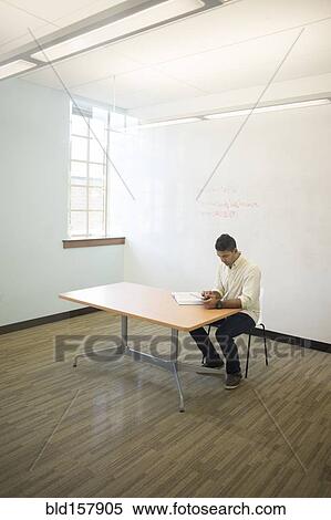 Stock Photography - Asian businessman working in empty office. Fotosearch