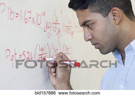 Stock Photograph - Asian businessman writing formula on whiteboard. Fotosearch