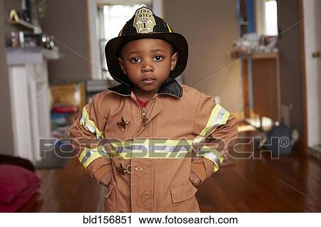 Stock Image - Black boy wearing firefighter Halloween costume. Fotosearch