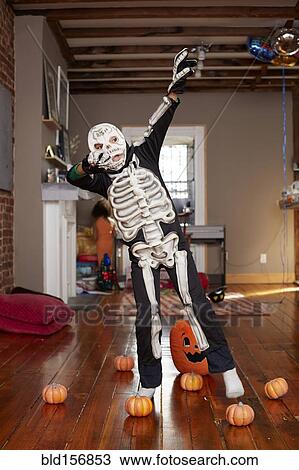 Stock Image - Black boy wearing skeleton Halloween costume. Fotosearch