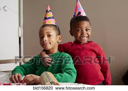 Black boys smiling in party hats View Large Photo Image Stock Image - Black boys smiling in party hats. Fotosearch