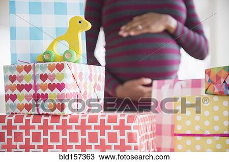 Black pregnant woman admiring gifts at baby shower View Large Photo Image Stock Image - Black pregnant woman admiring gifts at baby shower. Fotosearch