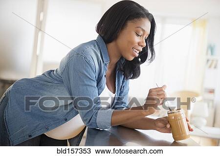 Black pregnant woman eating peanut butter in kitchen View Large Photo Image Stock Image - Black pregnant woman eating peanut butter in kitchen. Fotosearch