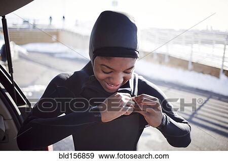 Stock Photo - Black teenage girl putting on wetsuit. Fotosearch