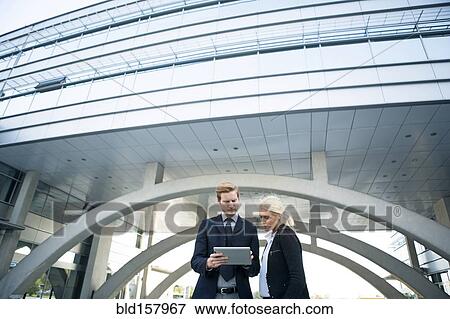 Stock Photo - Business people using digital tablet outside outdoors. Fotosearch