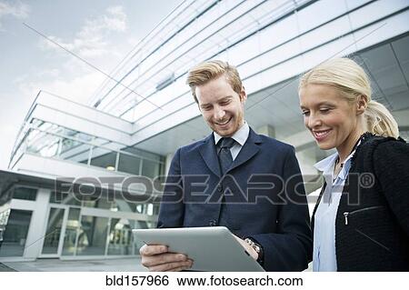 Stock Photograph - Business people using digital tablet outdoors. Fotosearch