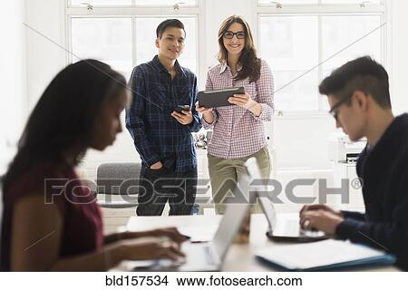 Picture - Business people using technology in office. Fotosearch