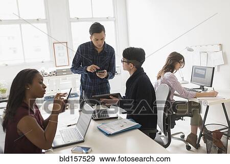 Stock Photo - Business people using technology in office. Fotosearch