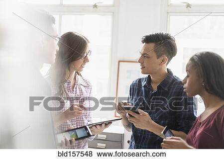 Business people working together in office with technology View Large Photo Image Stock Photo - Business people working together in office with technology. Fotosearch