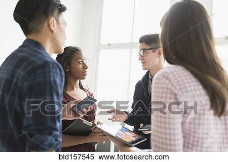 Stock Photography - Business people working together in office with technology. Fotosearch