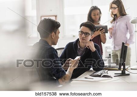 Businessmen working together in office View Large Photo Image Stock Photo - Businessmen working together in office. Fotosearch