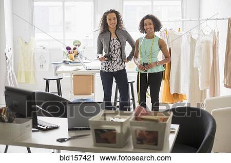 Stock Image - Businesswomen smiling in office. Fotosearch