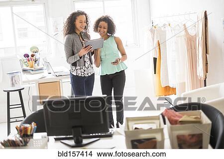 Picture - Businesswomen using digital tablet in office. Fotosearch