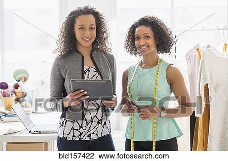 Businesswomen with digital tablet and tape measure in office View Large Photo Image Stock Image - Businesswomen with digital tablet and tape measure in office. Fotosearch