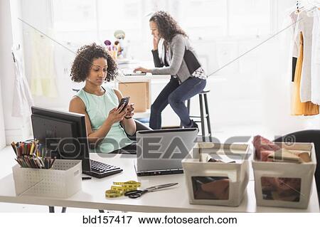 Stock Photo - Businesswomen working at desks in office. Fotosearch