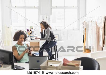 Businesswomen working at desks in office View Large Photo Image Stock Photograph - Businesswomen working at desks in office. Fotosearch