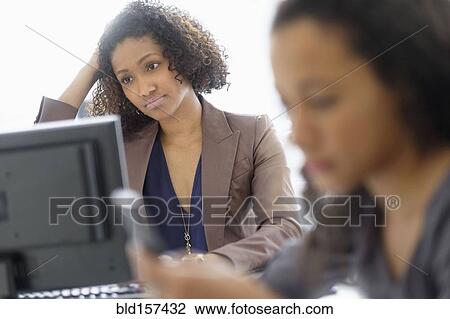 Stock Image - Businesswomen working in office. Fotosearch