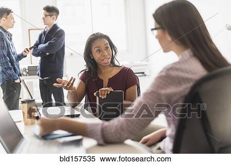 Stock Photography - Businesswomen working together in office. Fotosearch