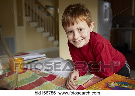 Stock Photograph - Caucasian boy doing homework at table. Fotosearch
