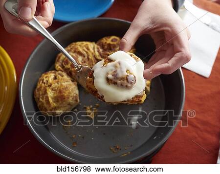 Stock Photo - Caucasian boy holding cinnamon bun. Fotosearch