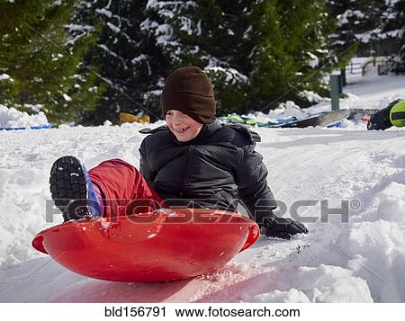 Caucasian boy sledding on snowy hill View Large Photo Image Stock Image - Caucasian boy sledding on snowy hill. Fotosearch