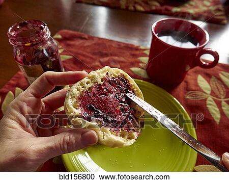 Stock Image - Caucasian boy spreading jam on english muffin. Fotosearch