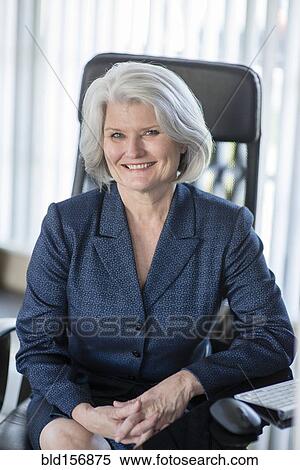 Caucasian businesswoman smiling at desk View Large Photo Image Stock Photography - Caucasian businesswoman smiling at desk. Fotosearch