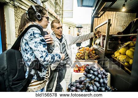 Caucasian couple buying produce at fruit kiosk View Large Photo Image Stock Photo - Caucasian couple buying produce at fruit kiosk. Fotosearch