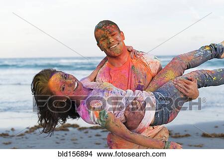 Caucasian couple splattered with paint powder on beach View Large Photo Image Picture - Caucasian couple splattered with paint powder on beach. Fotosearch