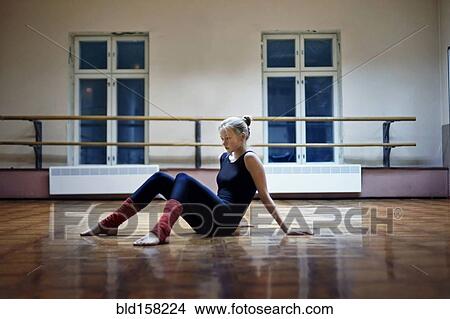 Picture - Caucasian dancer sitting on studio floor. Fotosearch