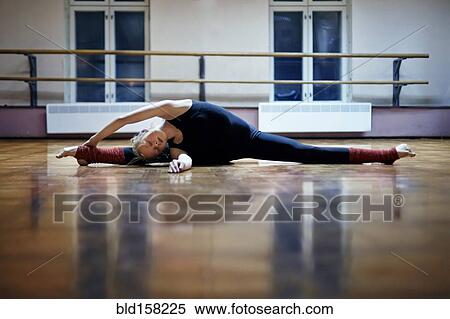 Caucasian dancer stretching doing splits on studio floor View Large Photo Image Stock Photography - Caucasian dancer stretching doing splits on studio floor. Fotosearch