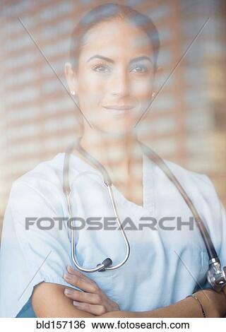 Caucasian doctor standing with arms crossed at window View Large Photo Image Stock Photograph - Caucasian doctor standing with arms crossed at window. Fotosearch