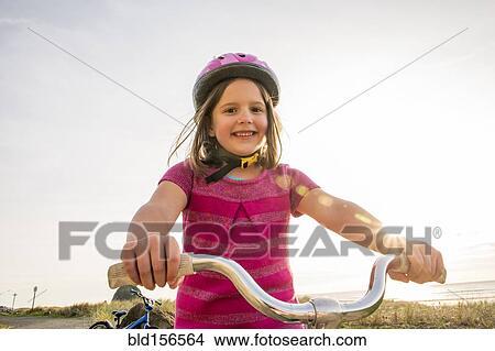 Picture - Caucasian girl riding bicycle outdoors. Fotosearch