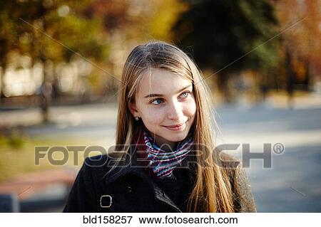 Stock Photo - Caucasian girl wearing coat and scarf outdoors. Fotosearch