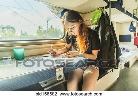 Caucasian girl writing on train View Large Photo Image Stock Image - Caucasian girl writing on train. Fotosearch