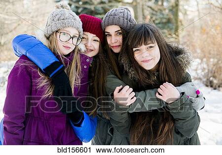 Stock Image - Caucasian girls hugging in snowy field. Fotosearch